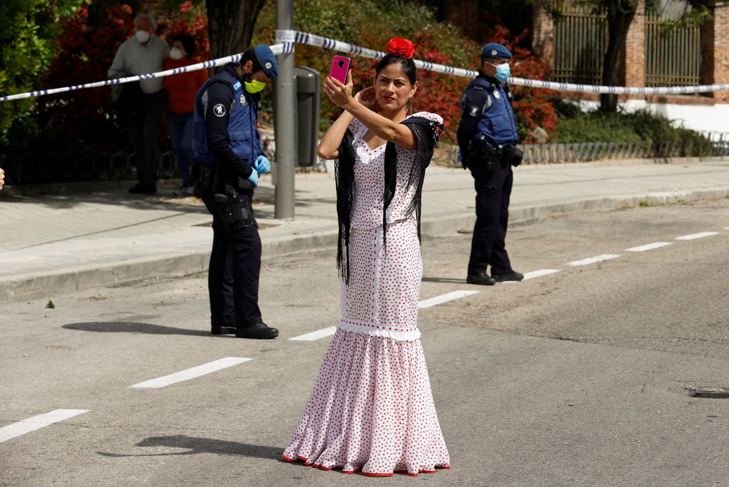 A woman dressed in traditional 'chulapa' dress observes the Day of San Isidro, the patron saint of Madrid, under security measures due to the coronavirus. Chema Moya / EFE